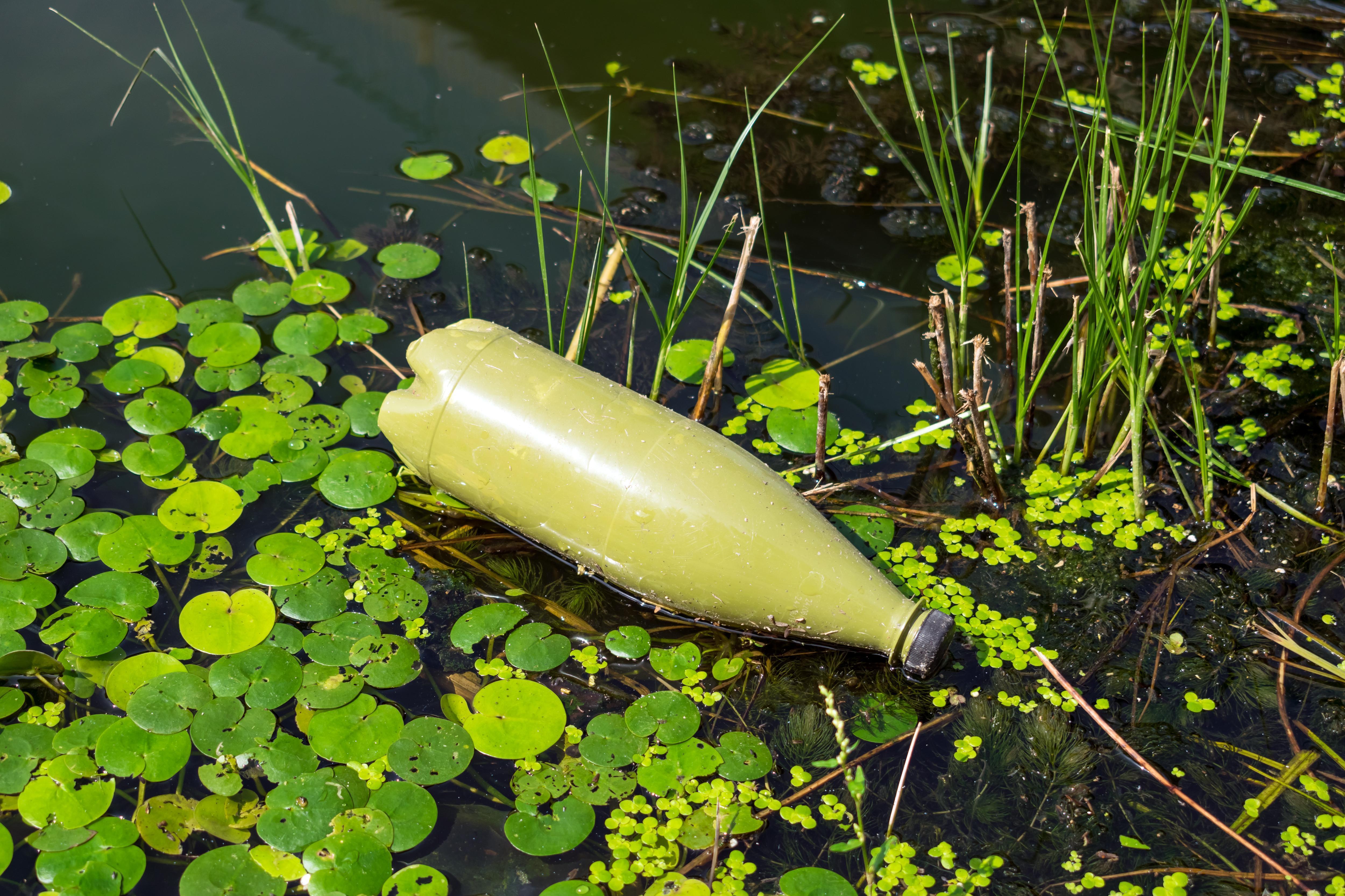 摄图网_303504491_水污染环境河中的绿色塑料瓶环境生态概念污染问题（企业商用）.jpg